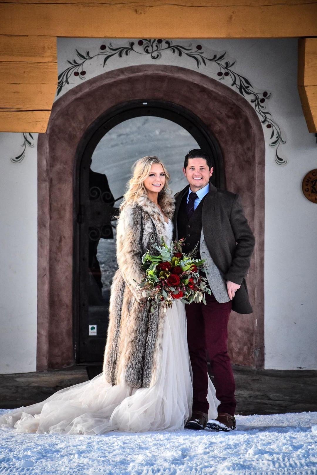 Bride and groom at Game Creek Club Vail Colorado winter wedding holding burgundy and blush bouquet with greenery by A Secret Garden florist